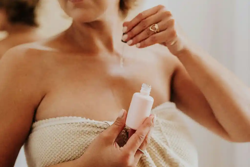 Close-up of woman applying hyaluronic acid serum to face with glowing, hydrated skin